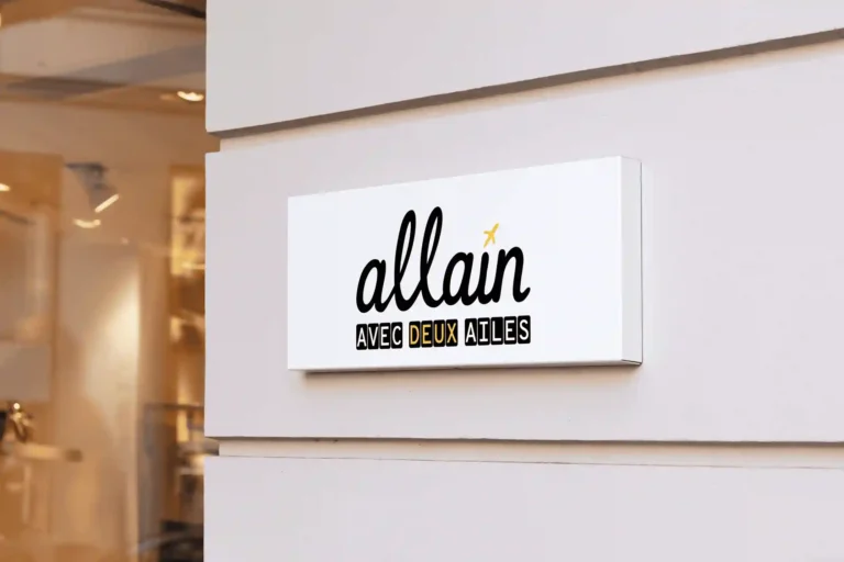 Enseigne extérieure Allain avec deux ailes fixée sur une façade